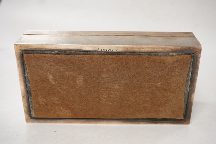 A George VI engine turned silver mounted rectangular cigarette box, by A. Wilcox, Birmingham, 1938, 17cm, with engraved inscription.